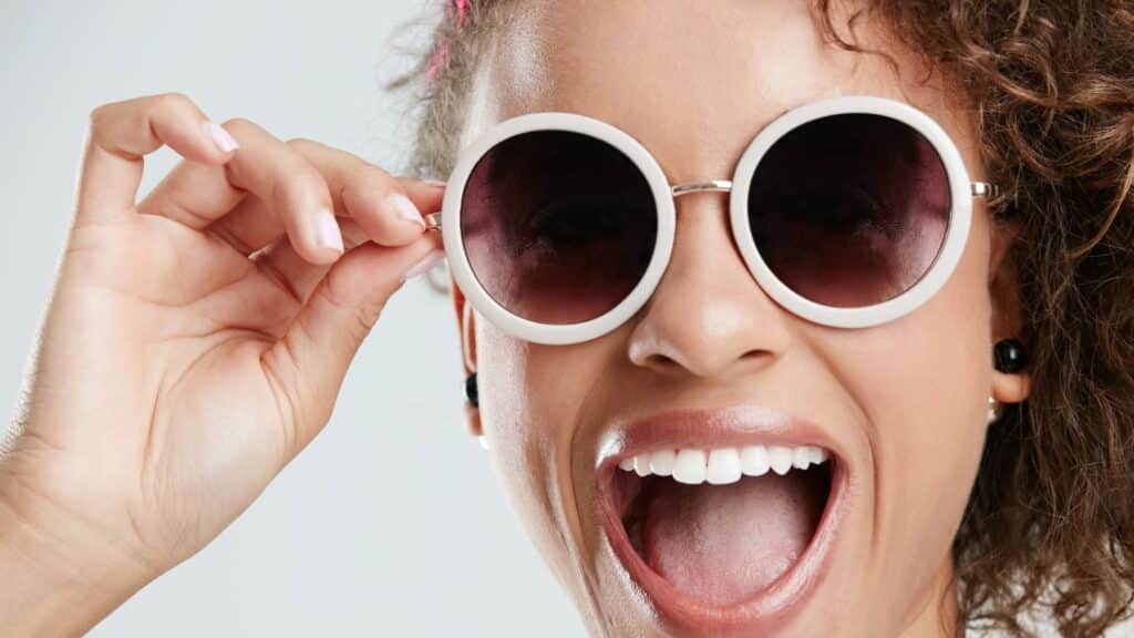 A woman with big personality in round, white sunglasses.
