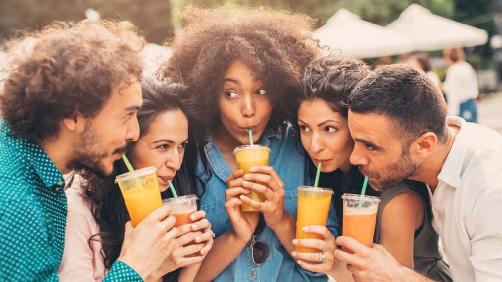 Five young adults drinking juice.