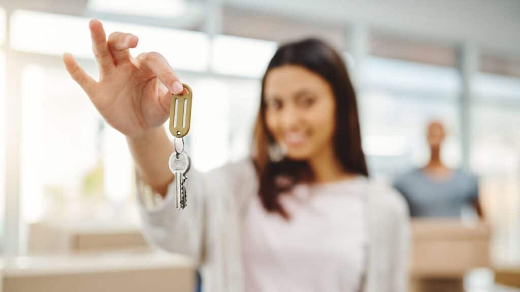 A young woman holds up a set of keys.