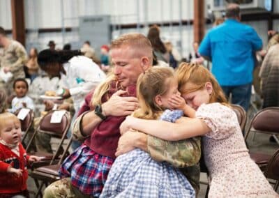 military man embracing his children